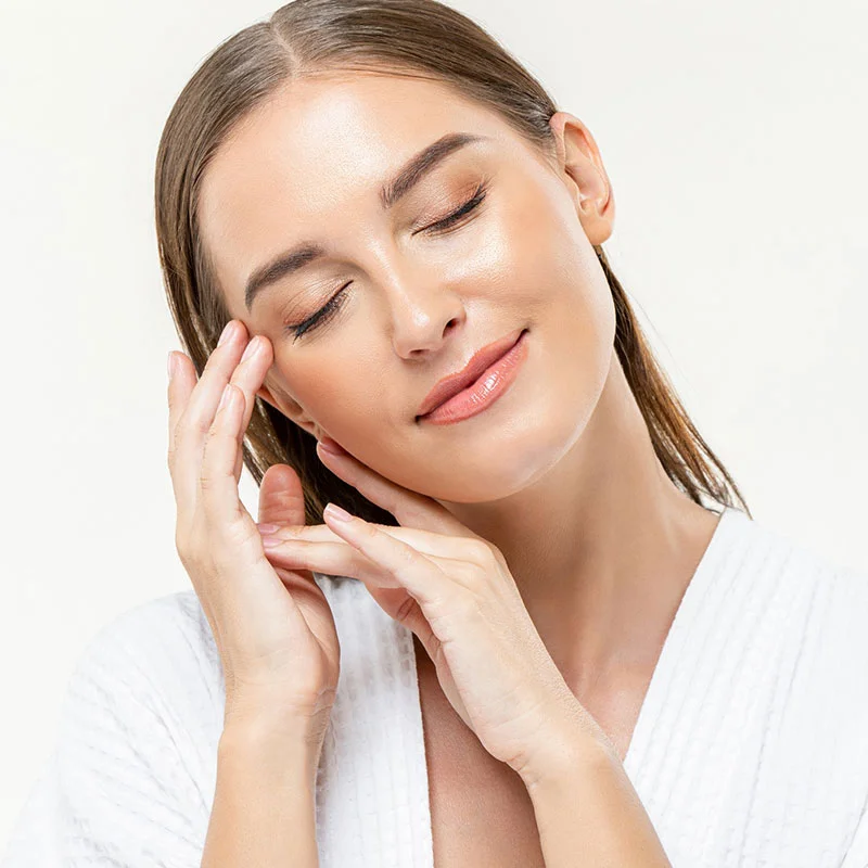 Woman with eyes closed feeling her face