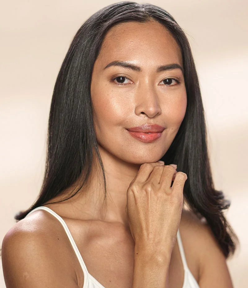Asian woman in white top and hand on her face